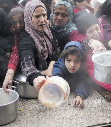  ?? AP ?? Palestinos hacen cola para recibir alimentos en Jan Yunis (Gaza)