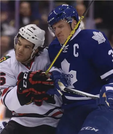  ?? STEVE RUSSELL/TORONTO STAR ?? Leafs captain Dion Phaneuf gets the worst of this collision with Chicago’s Andrew Shaw Friday night at the Air Canada Centre.