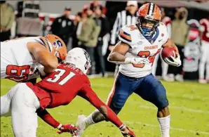  ?? Karl B DeBlaker / Associated Press ?? Syracuse's Sean Tucker (34) runs the ball against North Carolina State. Tucker became Syracuse’s single-season rushing leader, passing Joe Morris.