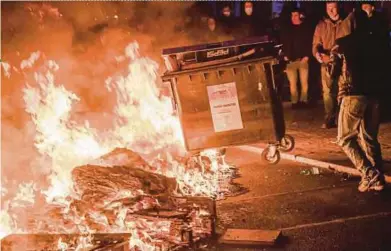  ?? AFP PIC ?? Rioters throwing a waste paper dumpster into a burning barricade during a May Day protest in Berlin.