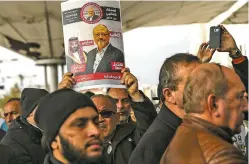  ?? EMRAH GUREL/ASSOCIATED PRESS ?? A man holds a poster showing images of Saudi Crown Prince Mohammed bin Salman and of journalist Jamal Khashoggi, describing the prince as ‘assassin’ and Khashoggi as ‘martyr’ in Turkish and Arabic during funeral prayers for Khashoggi on Friday in Istanbul.