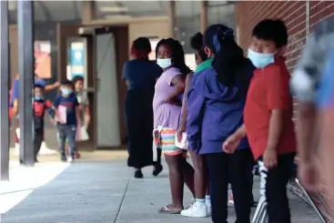  ?? JOE RONDONE/THE COMMERCIAL APPEAL ?? First graders walk back to class from their lunch break during summer learning academy at Treadwell Elementary School on July 21.