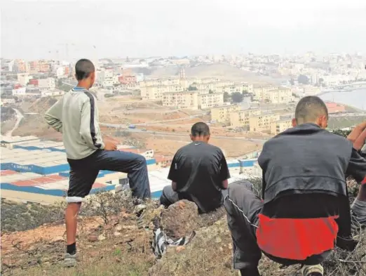  ?? // AFP ?? Varios menores observan Ceuta desde un monte de Castillejo­s