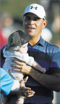  ??  ?? Gary Woodland with his infant son Jaxson after capturing the Waste Management Phoenix Open on Sunday.