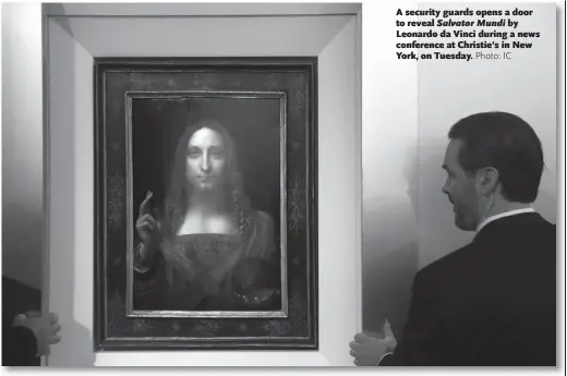  ??  ?? A security guards opens a door to reveal Salvator Mundi by Leonardo da Vinci during a news conference at Christie’s in New York, on Tuesday.