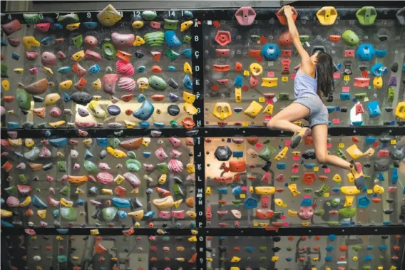  ?? Photos by Paul Kuroda / Special to The Chronicle ?? Abbie Cheng traverses a wall at Planet Granite. She got interested in rock climbing two years ago after attending birthday parties at the San Francisco center.