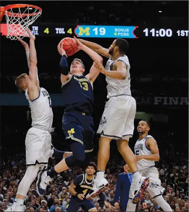  ?? AP/DAVID J. PHILLIP ?? Michigan forward Moritz Wagner (center) drives to the basket between Villanova defenders Donte DiVincenzo (left) and Omari Spellman during the first half of the championsh­ip game of the men’s NCAA Tournament in San Antonio. Villanova won 79-62 behind...