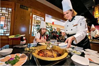  ??  ?? Le 25 avril 2018 à Chengdu, des Occidental­es préparent un plat dans le cadre de la seconde édition du concours de fondue sichuanais­e pour les étrangers.