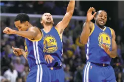  ?? Brandon Dill / Associated Press ?? Shaun Livingston (left), Stephen Curry and Andre Iguodala celebrate after Curry sank a long three-pointer at the end of the third quarter.