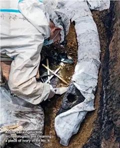  ??  ?? At the Sanxingdui site, archaeolog­ists are cleaning a piece of ivory in Pit No. 4.