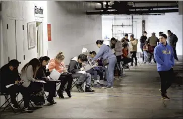  ?? Marcio Jose Sanchez Associated Press ?? HOSPITALIT­Y WORKERS line up to apply for unemployme­nt benefits in Los Angeles in March. At a time when many workers have lost employment to the pandemic, California has been plagued by fraudulent claims.