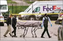  ?? MICHAEL CONROY / AP ?? A body is taken from the scene where multiple people were shot Friday at a FedEx Ground facility in Indianapol­is.