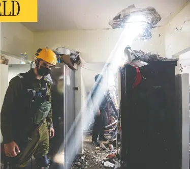  ?? AVI ROCCAH / REUTERS ?? Soldiers work at a building damaged by a rocket launched from the Gaza Strip, in Ashdod, southern Israel, on Tuesday.