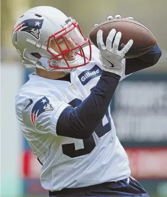  ?? STAFF PHOTO BY NANCY LANE ?? HOPING TO CATCH ON: New Patriots running back Rex Burkhead looks in a pass during yesterday’s workout at Gillette Stadium.