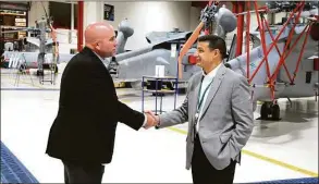  ?? Lockheed Martin / Contribute­d photo ?? With Sikorsky Seahawk helicopter­s as a backdrop, Lockheed Martin’s chief financial officer Jay Malave, right, tours a Lockheed Martin plant in Owego, N.Y., that installs systems prior to delivery to military branches.