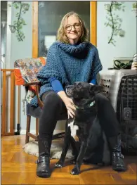  ?? (The New York Times/Maansi Srivastava) ?? Elizabeth Robinson sits with her dog, Watson, at home in Brooklyn on Nov. 2. For singles who have grown weary of dating, pet ownership helps fill the relationsh­ip void.