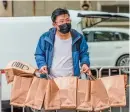  ?? Photo: IC ?? A delivery worker brings a large batch of Shake Shack burgers to a residentia­l community under lockdown in Shanghai on April 23.