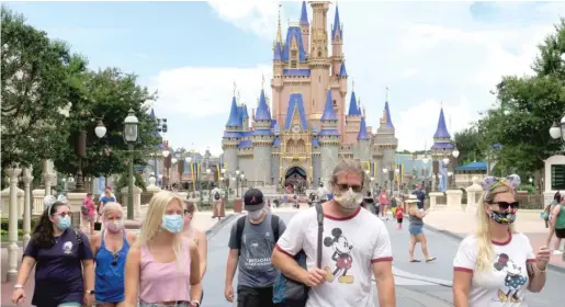  ?? JOE BURBANK/ORLANDO SENTINEL PHOTOS VIA AP ?? Guests wear masks on the reopening day of the Magic Kingdom at Walt Disney World on Saturday in Lake Buena Vista, Fla.