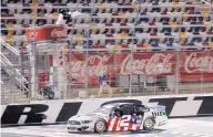  ?? GERRY BROOME/ASSOCIATED PRESS ?? Brad Keselowski crosses the finish line first in overtime of the Coca-Cola 600 with no fans in the stands early Monday at Charlotte Motor Speedway in Concord, N.C.