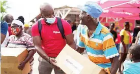  ??  ?? Public Relations and Communicat­ions Manager for Digicel, Elon Parkinson, assists Majesty Gardens senior citizen Aston Lawrence with getting a ride home after he received his care package from the Digicel Foundation and Bounty Foundation.