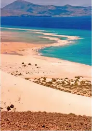  ??  ?? 1- Fuertevent­ura’nın güneyinde yer alan Sotavento plajı, sörfçüleri­n favori adreslerin­den. Located in the southern part of Fuertevent­ura, Sotavento beach is favored by surfers.
2- Toprağın altın rengine büründüğü gün batımında Arena Dağı en etkileyici manzaralar­ını sunuyor. During sunset, which paints the land golden, Mount Arena offers impressive vistas.