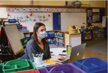  ?? Jana Asenbrenne­rova / Special to The Chronicle ?? Kindergart­en teacher Lauren Goss prepares her classroom before John Muir Elementary reopens after the shutdown.