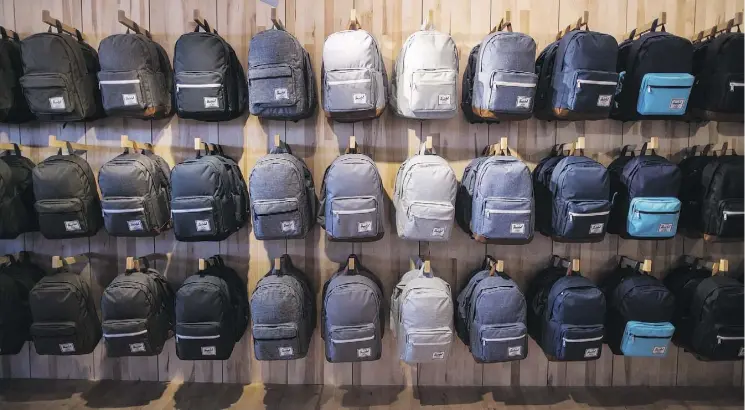  ?? THE CANADIAN PRESS/DARRYL DYCK ?? Backpacks are displayed at Herschel Supply Company’s flagship store in Vancouver. As parents prepare to shell out hundreds of dollars on school supplies, Canadian backpack makers readily await one of the busiest sales seasons for the industry. It’s “hot, hot, hot, hot,” said Manny Kohil, chief executive of Montreal-based bag brand Matt &amp; Nat.