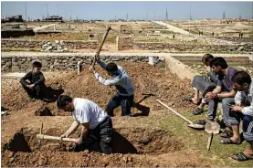  ?? FELIPE DANA / ASSOCIATED PRESS ?? Relatives and friends dig graves Saturday for two civilians killed in fighting between Iraqi security forces and Islamic State militants on the western side of Mosul, Iraq. U.S.led airstrikes flattened almost an entire block in the city.