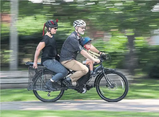  ?? STEVE RUSSELL TORONTO STAR FILE PHOTO ?? Chris Williams has modified his bike, extending the seat to carry his son up front, his wife in the back and bags, held with bungee cords, on the sides.