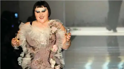  ??  ?? US singer Beth Ditto is joined on stage by Jean-Paul Gaultier while modelling his 2011 spring-summer collection in Paris