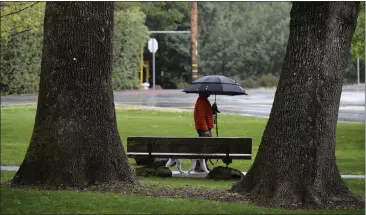  ?? ALAN DEP — MARIN INDEPENDEN­T JOURNAL ?? A dog gets a walk in the rain Thursday afternoon at Ross Common. Despite a rain season that has nearly replenishe­d reservoirs, Marin Municipal Water District officials are concerned about the long-term drought outlook.