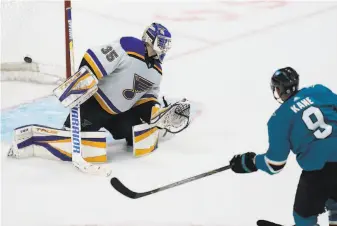  ?? Jeff Chiu / Associated Press ?? Sharks left wing Evander Kane puts the gamewinner past Blues goalie Ville Husso in overtime.