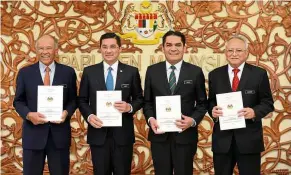  ??  ?? In black and white: Azmin with (from left) Felda chairman Tan Sri Megat Zaharuddin Megat Mohd Nor, his deputy Senator Dr Mohd Radzi Md Jidin and Othman showing the Felda White Paper at Parliament.