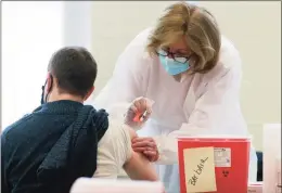  ?? Christian Abraham / Hearst Connecticu­t Media file photo ?? Karen Lynch, a nurse at Danbury Hospital, administer­s the Moderna COVID-19 vaccinatio­n to Danbury teachers and school district staff at a vaccine clinic at Rogers Park Middle School in Danbury on March 6. Danbury employees who have chosen not to get vaccinated were placed on leave 118 times over seven weeks for failure to turn COVID-19 test results in on time.