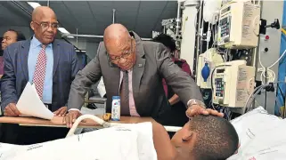  ??  ?? Healthcare: President Jacob Zuma with a patient at the Steve Biko hospital. Health Minister Aaron Motsoaledi, left, signed off an NHI white paper in December 2015 and a revised one in June 2017. / GCIS