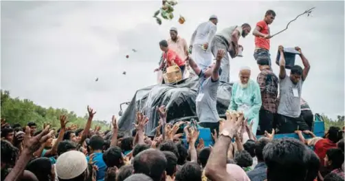  ?? — AFP ?? BANGLADESH: Bangladesh­i volunteers from the Chhagalnai­ya village council distribute food donations to Rohingya Muslim refugees at Naikhongch­hari in Chittagong.