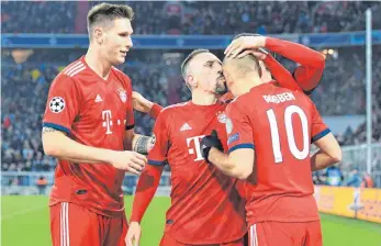  ?? FOTO: DPA ?? Niklas Süle (li.) und Franck Ribéry mit einem Küsschen auf die Glatze gratuliere­n Arjen Robben zu einem seiner zwei Tore beim 5:1 gegen Benfica Lissabon.