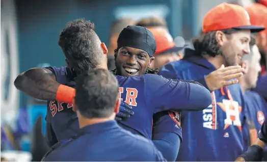  ?? Karen Warren photos / Houston Chronicle ?? Cameron Maybin, whose three-run homer in the third put the Astros up for good, is being embraced by George Springer and his new Astros teammates.