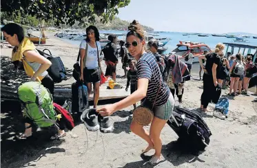  ?? Picture: BEAWIHARTA/REUTERS ?? AWAITING RESCUE: Foreign tourists leave Gili Trawangan island after an earthquake hit Lombok island in Pemenang, Indonesia