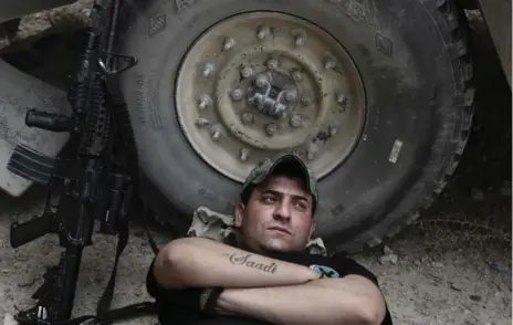  ?? MAYA ALLERUZZO/THE ASSOCIATED PRESS ?? Sgt. Ahmed Kamel, 26, of Iraq’s elite counterter­rorism forces, rests at a battle position on the southern edge of Fallujah, Iraq.