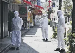  ??  ?? Employees from a restaurant in Japan stand outside