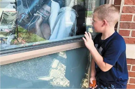  ?? — ap ?? Get well soon: a boy waving outside his father’s hospital room in Osage Beach, Missouri. the father had chosen not to be vaccinated against Covid-19 but his long hospitalis­ation has forced him to reconsider.