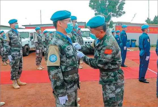  ?? YU HAO / XINHUA ?? Pilots and ground support soldiers of a helicopter squadron that form a part of China’s peacekeepi­ng force in the Abyei area, on the border of South Sudan in Africa, are awarded the UN Peace Medal of Honor on Aug 19.