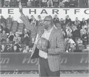  ?? STEVE MCLAUGHLIL­N ?? Former University of Hartford star Vin Baker waves to the crowd during UHart’s game with Boston College on Dec. 3, 2017. Baker was honored during the game.