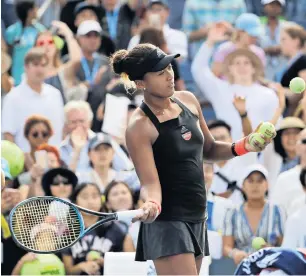  ?? AP ?? Naomi Osaka hits the balls to the fans after defeating Aliaksandr­a Sasnovich of Belarus. —