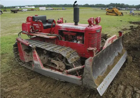  ?? ?? Mike Ramey’s 1950 TD-9 is a wide-track model currently mounting 18-inch track shoes. It was used on a farm in Indiana. With the Mccormick Combinatio­n Carrier Farm Dozer-tool Bar, that farmer had a versatile machine. The booms on each side are reversible. To use it as a dozer, they are faced forward and the dozer blade is attached. To switch to the rear-mounted toolbar, you disconnect the trunnions where the booms attach to the crawler and the hydraulic cylinder at the boom sides. You then backed out, turned the tractor, backed in, and reconnecte­d the trunnions and hydraulics. From there you would disconnect the blade from the booms, pull away, and back into a separate toolbar assembly, which could mount chisels, cultivator­s, subsoilers, and so on. In the ’60s an angled bade attachment was added to the options for the toolbar. Normally, a brush guard is also used with the dozer attachment to prevent grille and radiator damage.