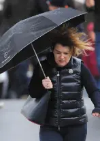  ??  ?? BATTEN DOWN THE HATCHES: Left, people walking the dog on Salthill promenade in Galway city. And above, brollies out in Dublin. Photos: Liam McBurney & Frank McGrath