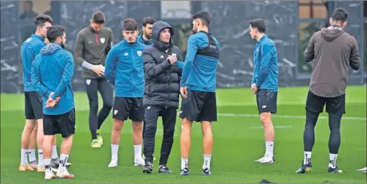  ??  ?? Marcelino saluda a Nolaskoain, que sale de una larga lesión, ante la atenta mirada de Vencedor en la lluviosa sesión de ayer en Lezama.