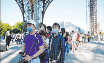  ?? Thibault Camus The Associated Press ?? People line up Thursday to visit the Eiffel Tower, which reopened after the coronaviru­s pandemic led to the Paris landmark’s closure.