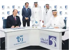  ?? Adnoc ?? Arthur Crossley, Tecnicas Reunidas chief executive for upstream, left, signs the EPC agreement with Adnoc Onshore chief executive Yasser Al Mazrouei